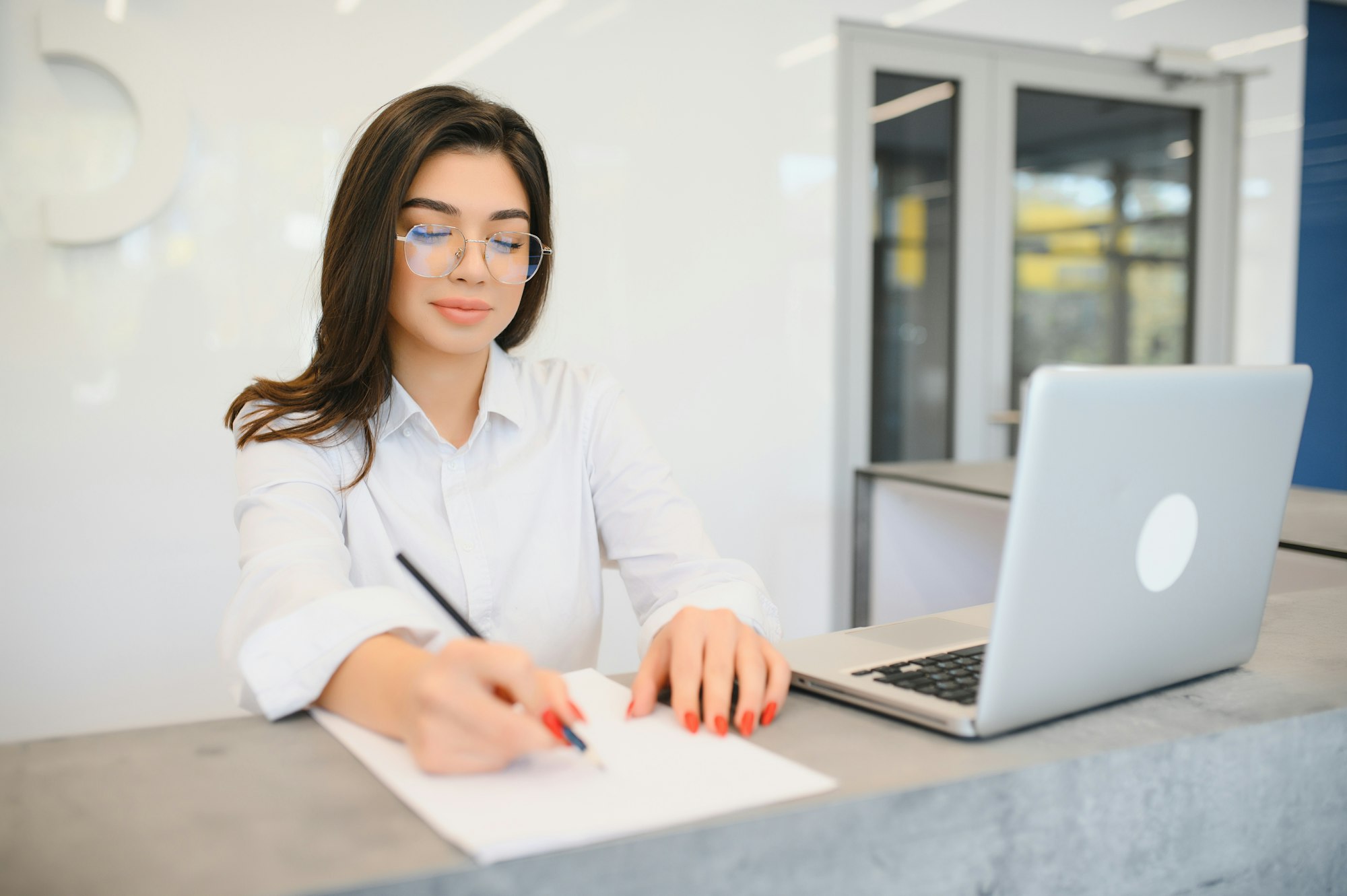 friendly young woman behind the reception desk administrator